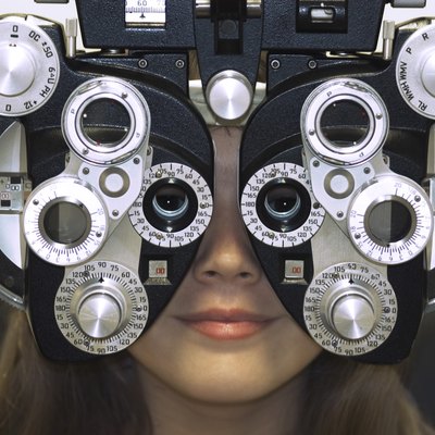 Close-up of a young woman getting an eye test with a phoropter