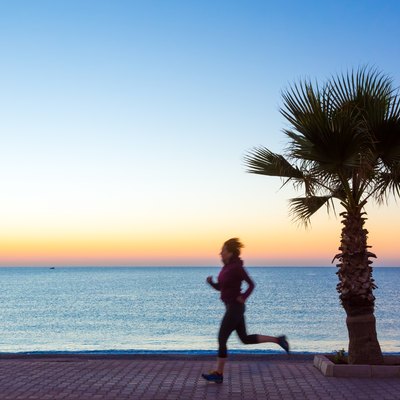 Young Woman jogging on Seafront making Morning Fitnes