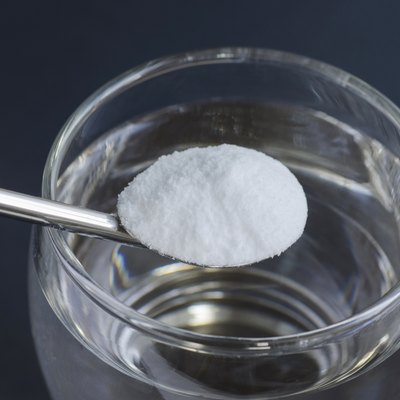 Spoon of baking soda over glass of water