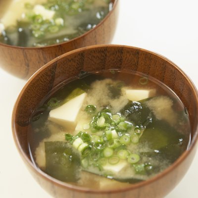 Tofu and seaweed in Miso soup, close up, white background