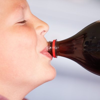 Close Up Of Boy Drinking Soda From Bottle