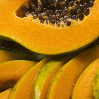 Studio shot of papaya, halved and cut into slices.