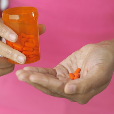Woman's hands holding pills and bottle, close-up