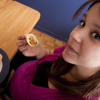 Young pregnant woman eating junk food