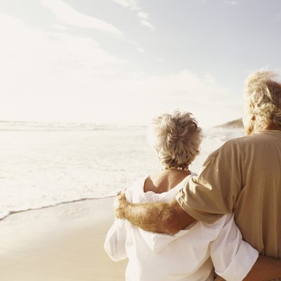Rear View of a Senior Couple Standing on a Beach With Their Arms Around Each Other