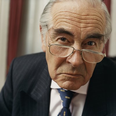 Portrait of a Sulking Businessman Wearing Spectacles and a Pinstripe Suit