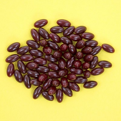 Cranberry capsules on yellow background