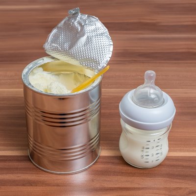Powdered milk formula in can and bottle for feeding baby