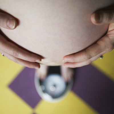 Pregnant woman standing on a scale