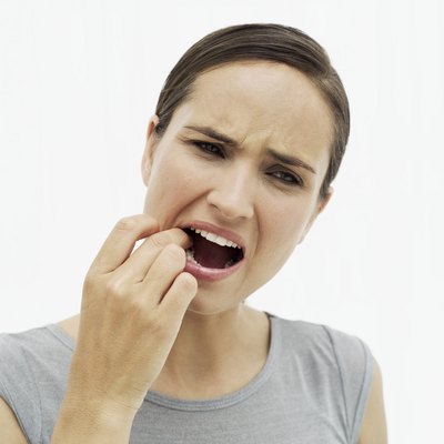 woman feeling her tooth with her finger