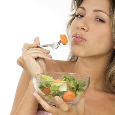 Young woman eating salad