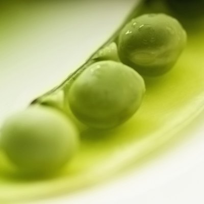 Image of an open pea pod on a plate, close-up, selective focus