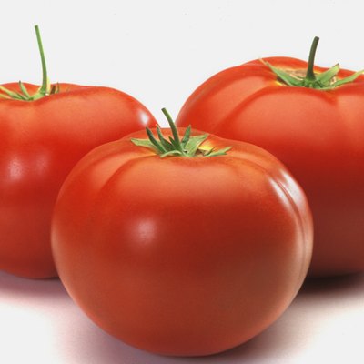 Three tomatoes on counter, close-up