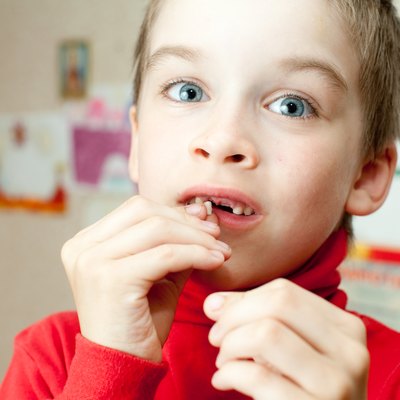 Boy holding missing teeth