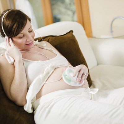 pregnant woman listening to her baby heartbeat