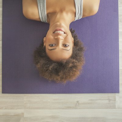 Smiling African Woman Lying on the Yoga Mat