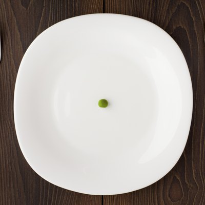 One pea on a white plate