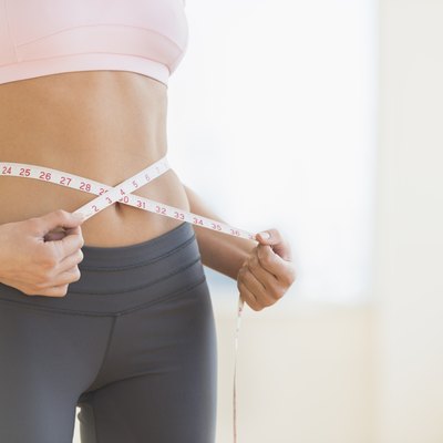 USA, New Jersey, Jersey City, Woman measuring waist