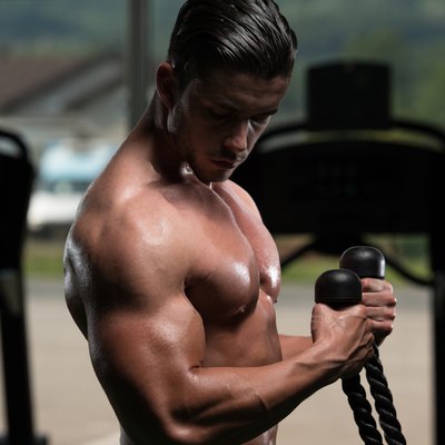 Young Man Doing Heavy Weight Exercise For Biceps