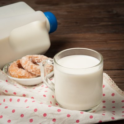Glass of milk with doughnut on wood