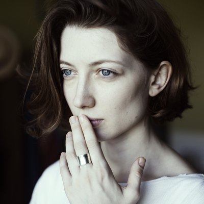 Portrait of a woman holding her hand to her mouth
