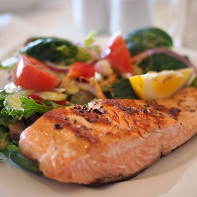 Plate of broiled salmon with asparagus and salad