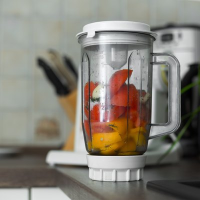Blender with fresh vegetables on kitchen table