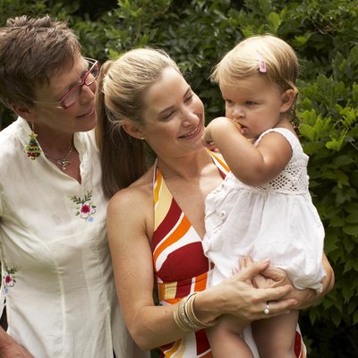 Grandmother, mother, and granddaughter (20-24 months) in yard