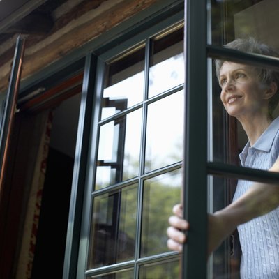Senior woman looking through open window