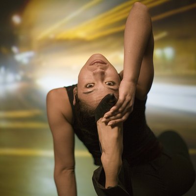 Young woman stretching, street scene projected in background