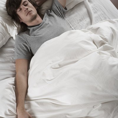 Young man sleeping in bed, overhead view