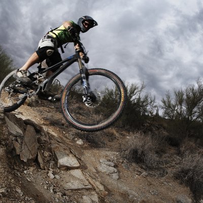 Man mountain biking down steep rocky path, low angle view