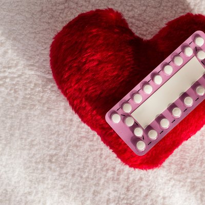 Oral contraceptive pills on red heart