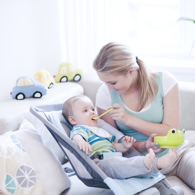 Teenage girl feeding baby boy