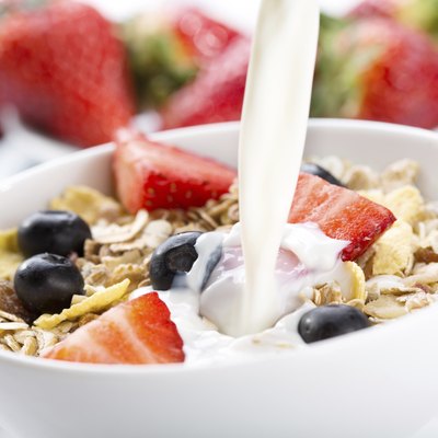 pouring milk into bowl of cereals
