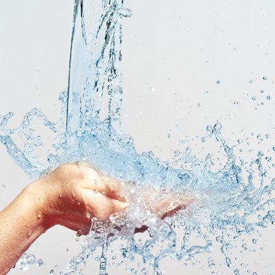 woman hand with water splashes and drops