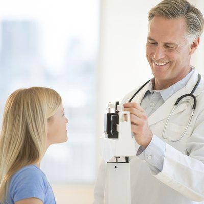 Doctor Examining Girl's Weight In Clinic
