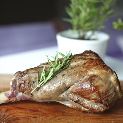 Roasted leg of lamb with rosemary on the cutting board