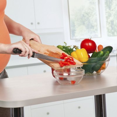 pregnant woman cooking at kitchen