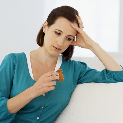 Young woman holding ginger biscuit eaten to help prevent onset of morning sickness