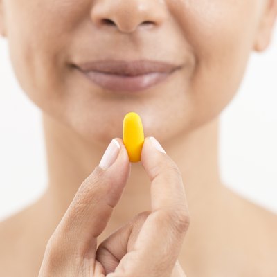 Woman Holding And Showing Yellow Pill