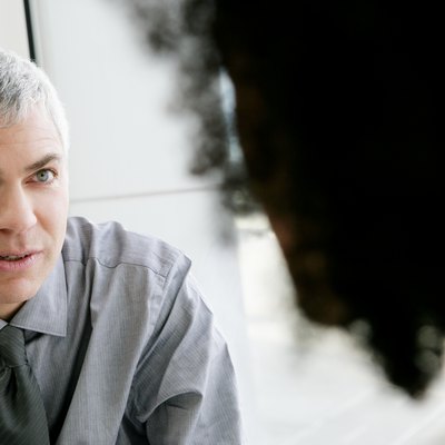Mature businessman talking with colleage in airport.