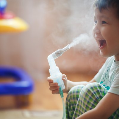 Little boy makes inhalation at home, taking medication to bronchial