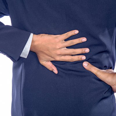 Backache concept bending over in pain with hands holding