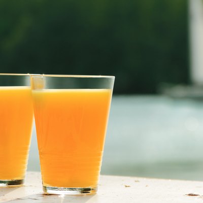 two glasses of orange juice against sea