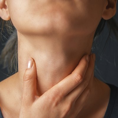 Woman holds her throat, sore throat