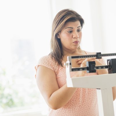 USA, New Jersey, Jersey City, Woman standing on scale