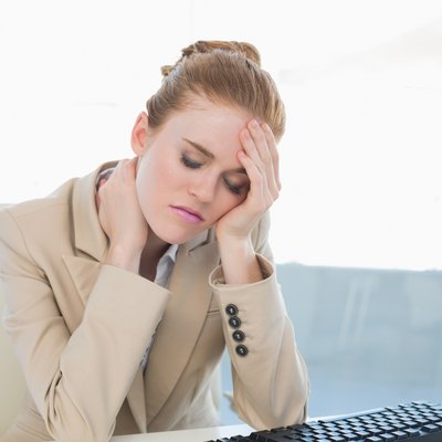 Businesswoman with neck pain at office desk