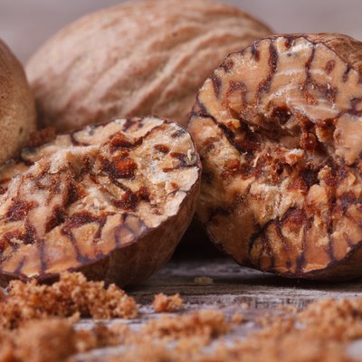 sliced and grated nutmeg on an old wooden table