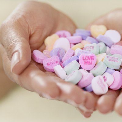Close-up of a Person Holding a Pile of Heart-shaped Love Sweets